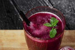 A picture of a glass of beetroot juice resembling VitalSTART with a sprig of mint